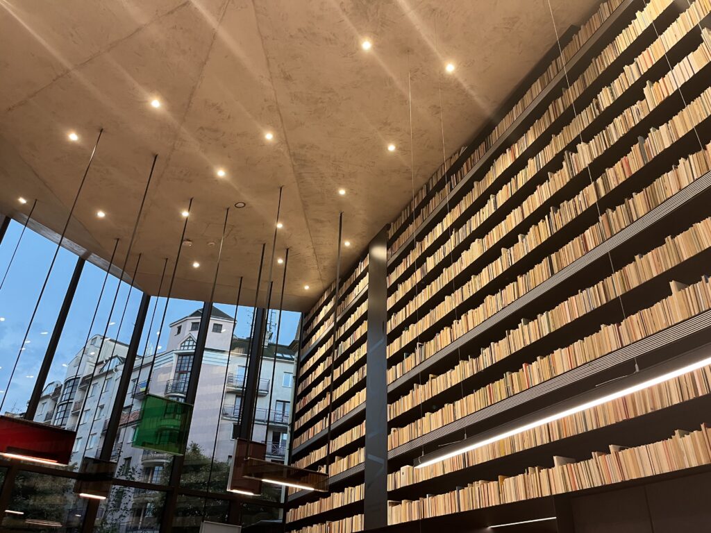 Foyer einer Bibliothek mit einem hohen Regal voller Bücher.